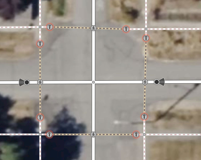 An screenshot of the OpenStreetMap iD editor where, at each corner of a four-way road intersection, a pair of guard *t*owers has been inserted instead of a power of *l*owered crossings