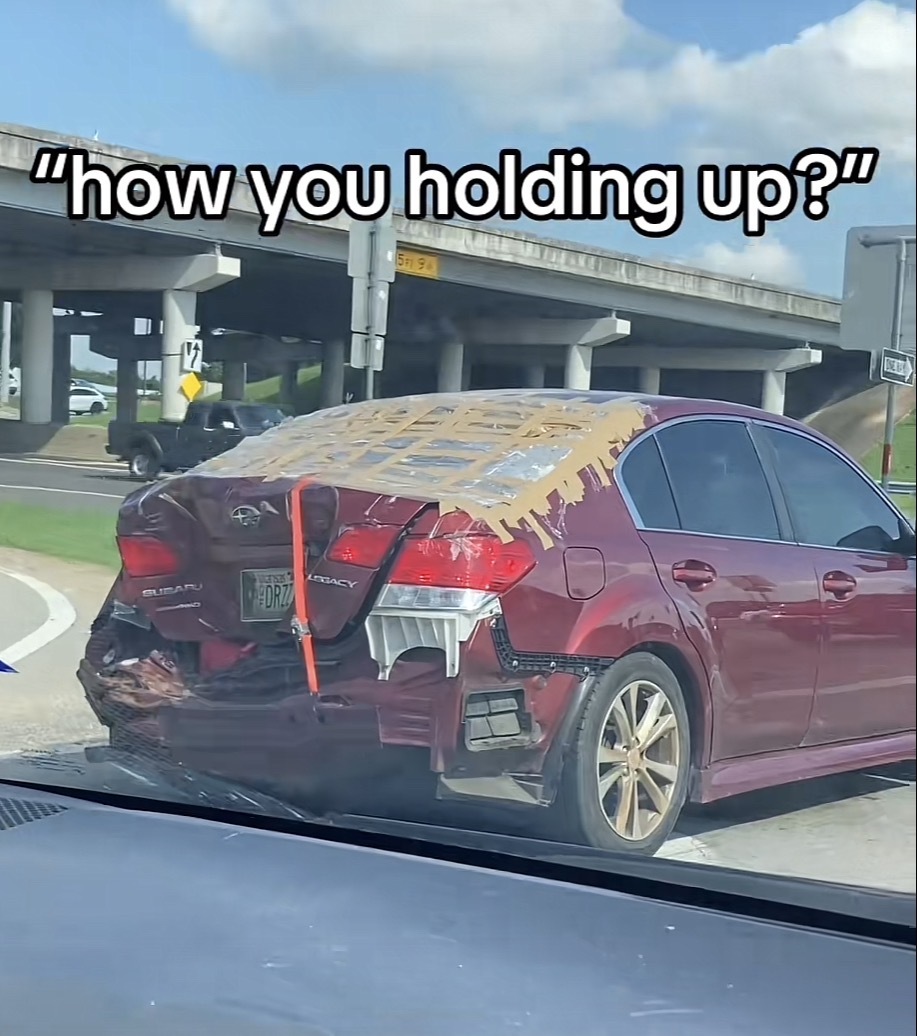 Photo of a car seemingly held together with duct tape with the caption "how you holding up?"