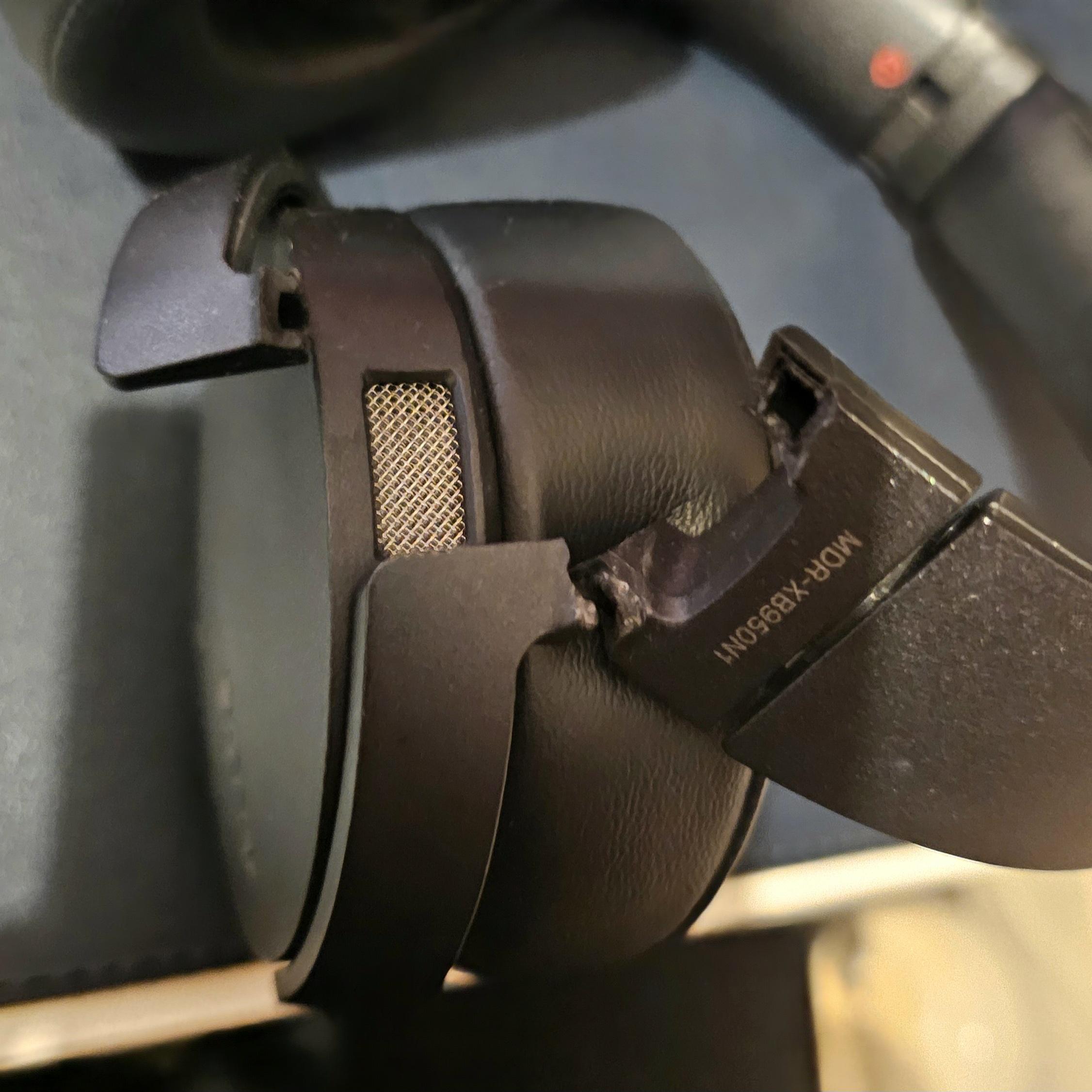 A close up picture of headphones with the plastic connecting the headband to one of the cups being snapped